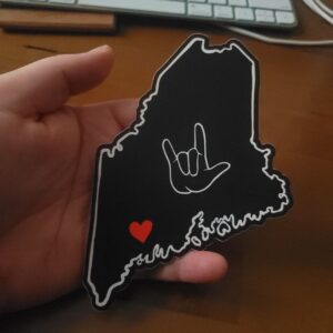 Large sticker in a hand, showing the sticker is approximately the same size of a hand.